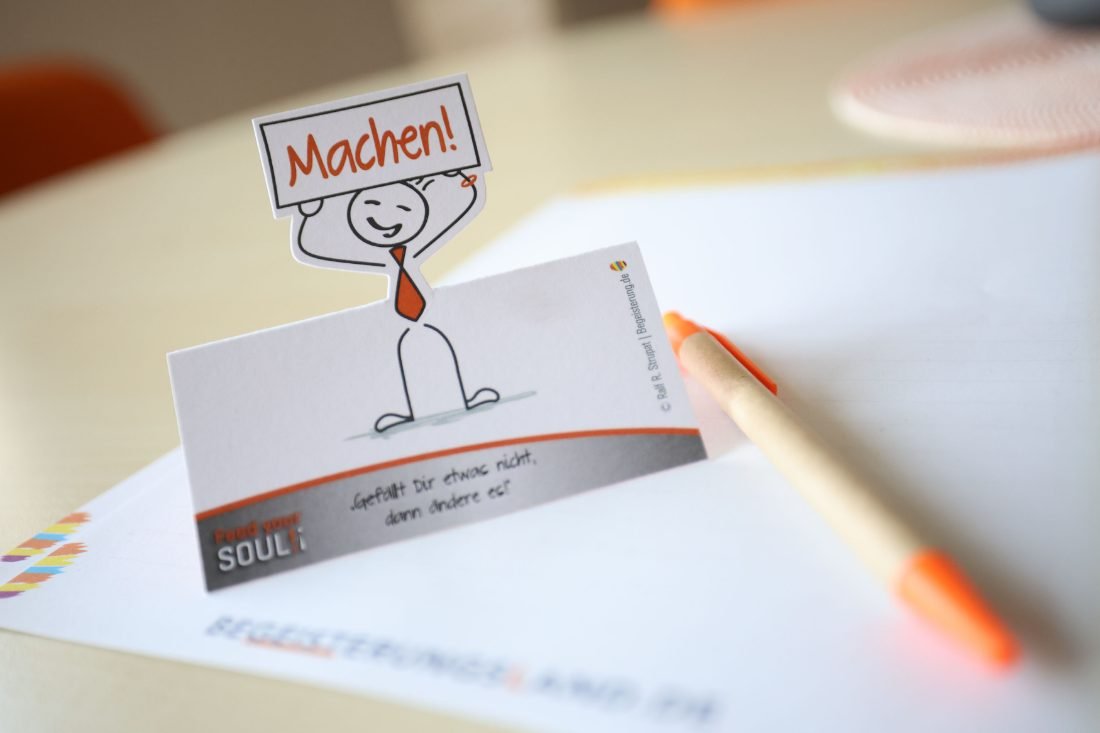 Aufsteller mit der Aufschrift Machen! und dem Spruch: Gefällt Dir etwas nicht, dann ändere es!
